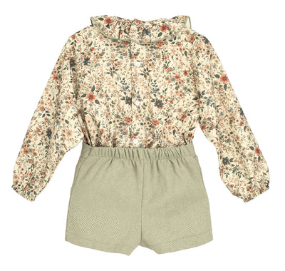 Floral blouse and green shorts set on a white background